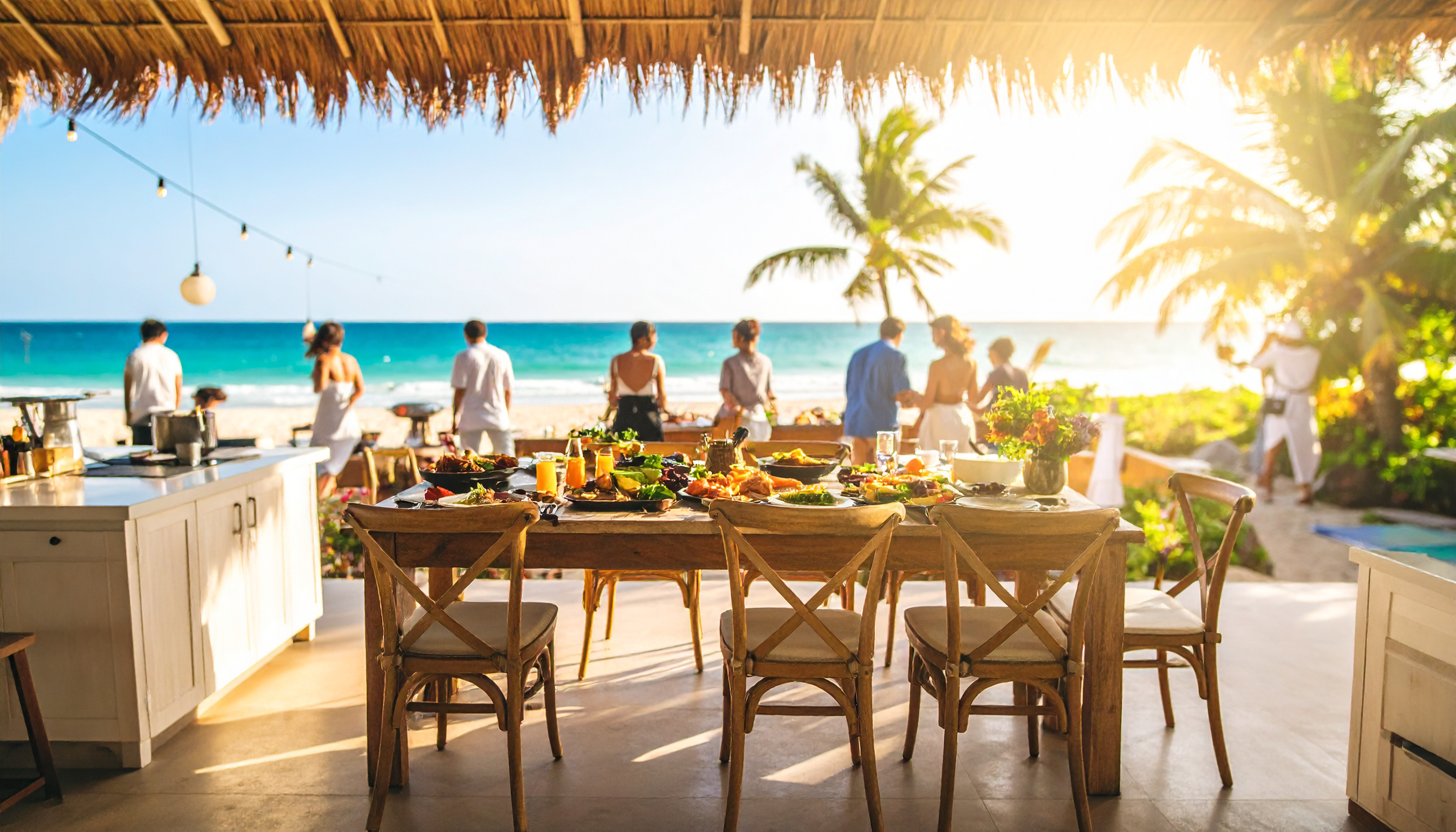 Outdoor dining area with a view of the ocean and people in the background.